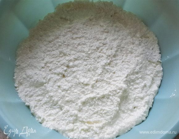 Смешать манку с творожным тестом и выложить половину аккуратно в форму.