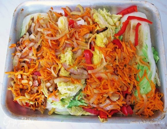 Спассеровать лук, морковь, чеснок.
В форму выложить капустные четвертинки, сверху распределить пассерованные овощи и болгарский перец.