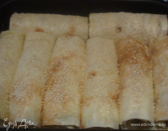 Желток смешать с 2 столовыми ложками молока, смазать рулетики и присыпать кунжутом.