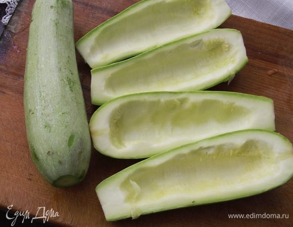 Кабачки разрезать вдоль, чтобы получилась лодочка. Удалить мягкую серединку, не задевая твердую часть. Посолить и сбрызнуть оливковым маслом.