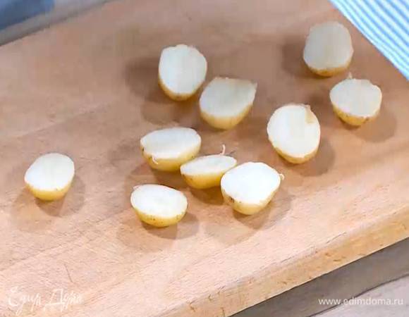 Картофель, не очищая, отварить до готовности, затем разрезать пополам.