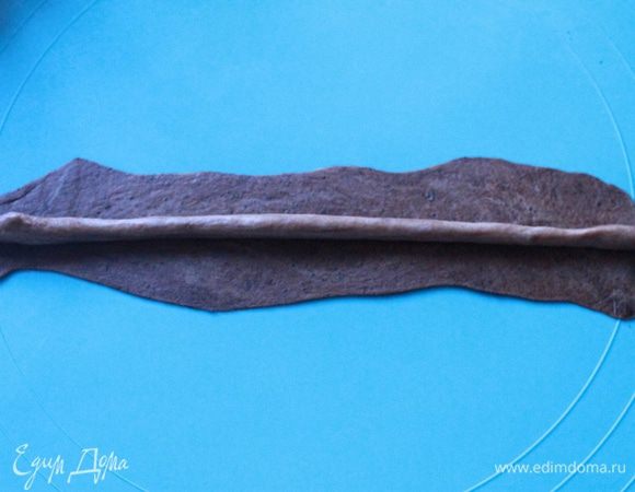 Берем кусочек темного теста и раскатываем в тонкую ленту. Затем из кусочка более светлого катаем колбаску и выкладываем ее на темную ленту. Защипываем края. 