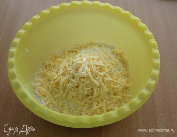 Смешать муку и разрыхлитель, добавить тертый сыр.