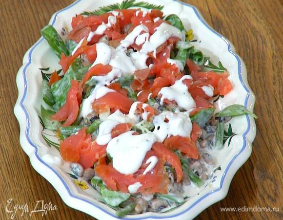 Форель нарезать небольшими кусочками, выложить на салат и полить все оставшейся заправкой.