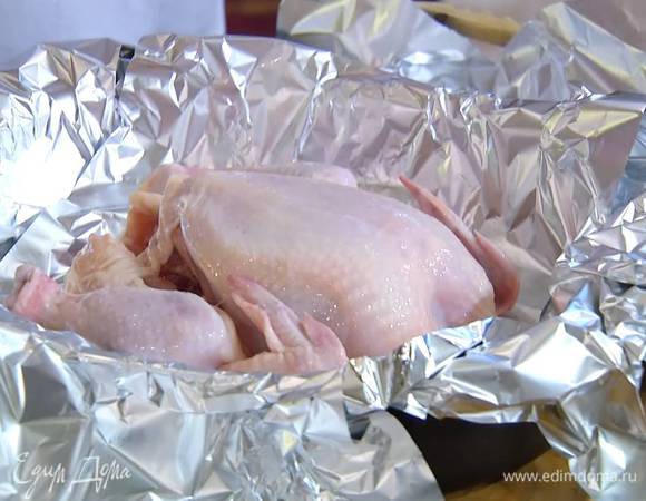 Тушку цыпленка вымыть, обсушить, посолить и поперчить изнутри, затем выложить грудкой вверх на противень, выстеленный фольгой так, чтобы свешивались края.
