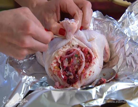 Наполнить цыпленка вишневой начинкой как можно плотнее, затем скрепить отверстие зубочистками, ножки тоже скрепить вместе зубочистками. Если останется начинка, выложить ее рядом с цыпленком на фольгу.