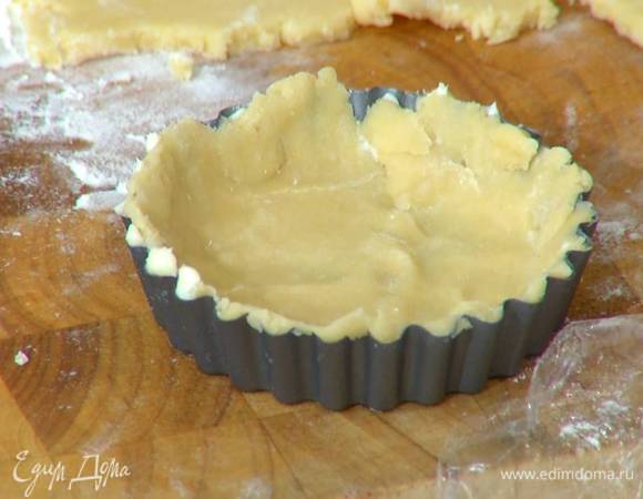 Небольшие формы для выпечки смазать оставшимся сливочным маслом, равномерно распределить тесто по дну и стенкам, сформировав бортики, и часто наколоть вилкой.