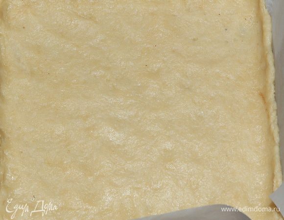 Противень с высокими бортиками выстилаем пекарской бумагой, раскатываем светлое тесто и выкладываем его первым слоем.