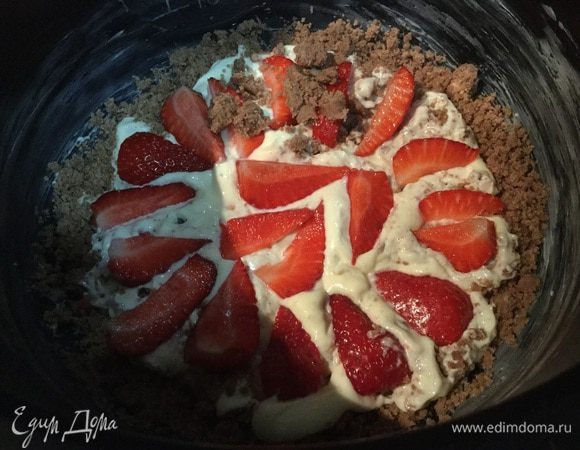 Дно мультиварки смажьте сливочным маслом, выложите 1/3 часть шоколадной крошки, 1/2 часть творожной начинки, половину клубники. Повторите слои, сверху — оставшуюся шоколадную крошку.