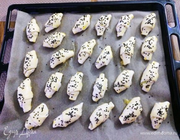 Смазываем круассаны желтком и обсыпаем кунжутом/маком.