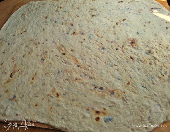 Через 1,5 часа переносим тесто на большую доску с мукой и раскатываем в тонкий пласт.