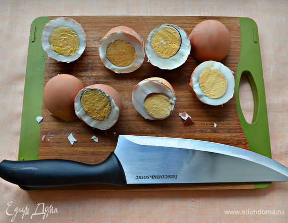 С помощью большого острого ножа резким движением разделите яйцо по-полам. Делайте это предельно аккуратно, чтобы не пораниться. Затем, с помощью чайной ложки выньте яйцо из скорлупы, оставляя саму скорлупу целой.