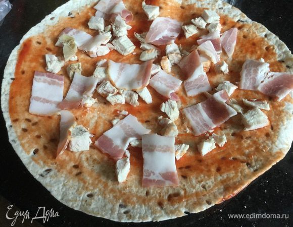 Бекон нарежьте тоненькими полосочками и выложите сверху.