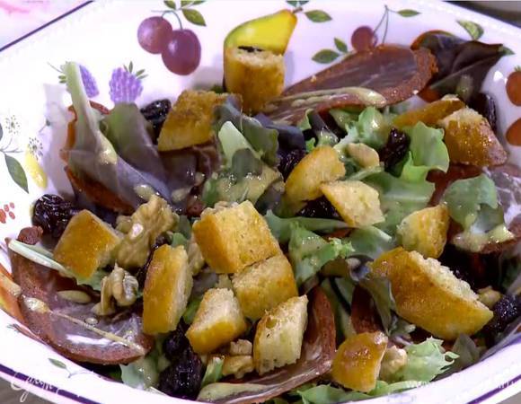 Грецкие орехи поломать руками на крупные кусочки и посыпать салат, сверху разложить вишню и крутоны.