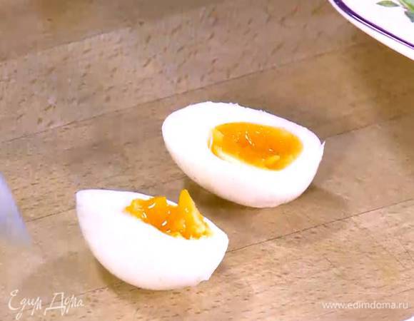 Яйца почистить, разрезать пополам и выложить на салат.