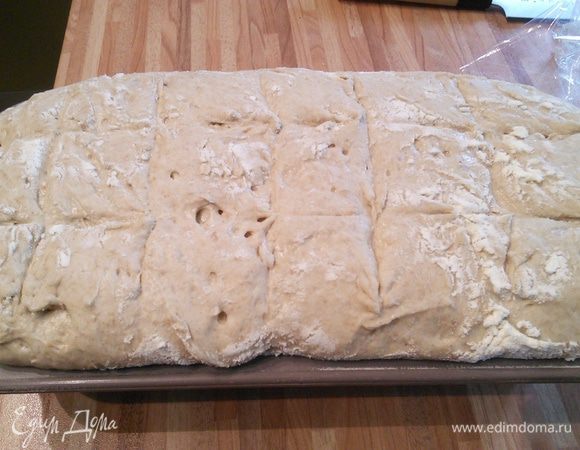 Сделать надрезы. Духовку разогреть до 230°С. Поместить мисочку с горячей водой на нижний ярус духовки и выпекать при 210°С 40-50 минут. Проверить на сухую палочку. 