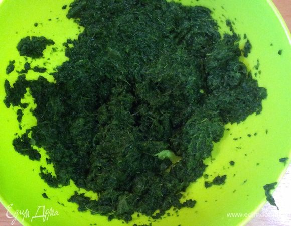 Тесто и шпинат размораживаем. Тесто я беру слоеное бездрожжевое. В упаковке 2 листа. Шпинат замороженный измельченный. Готовим начинку: отжимаем шпинат от влаги, сливаем жидкость.