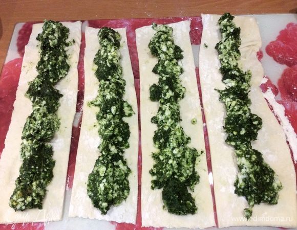 На каждую полоску равномерно выкладываем начинку по всей длине и защипываем полоски пальцами. Руки должны быть сухими, можно посыпать мукой. Заправляем начинку внутрь так, чтобы у нас получилось 8 колбасок.