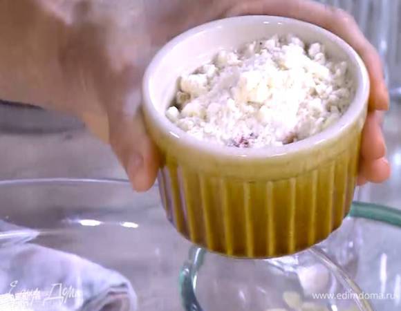 Сверху, не утрамбовывая, разложить охлажденную крошку, посыпать все оставшимися миндальными лепестками.