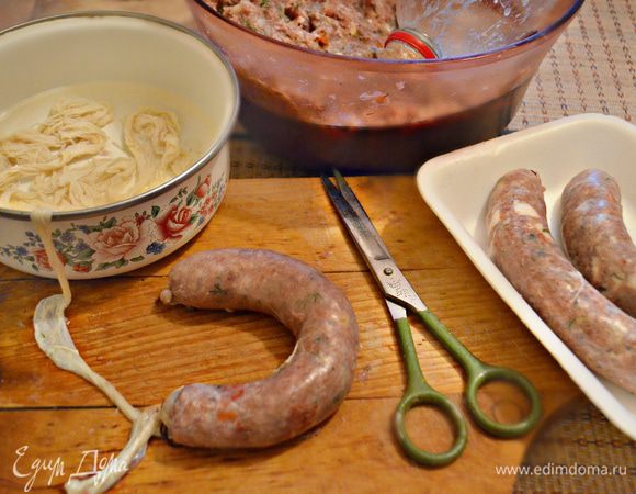Оболочку (свиную чреву в соли) предварительно замочите в воде на 15 мин, затем слейте воду и промойте. Наполняйте оболочку с помощью специальной насадки для мясорубки или же с помощью пластиковой бутылки, срезав верхнюю 1/3 часть. Такое незамысловатое приспособление мне даже больше нравится, нежели специальная насадка на мясорубку, которая у меня тоже имеется. Итак, на горлышко бутылки наденьте чреву. В бутылку положите фарш и с помощью ложки проталкивайте в горлышко, наполняя тем самым чреву. Старайтесь равномерно распределять фарш внутри чревы и слишком плотно не набивать ее (во время готовки чрева может лопнуть).
С помощью кулинарной нити завяжите концы.Обычно я занимаюсь процессом формирования колбасок вечером, во время просмотра телевизора. Процесс проходит быстро и не утомительно. К выходным для выезда на дачу или на природу уже все готово! Сложите колбаски в лоток или контейнер. Часть, что вы не успеете использовать для жарки в ближайшие пару дней, заморозьте. И в следующие выходные у вас уже будет все наготове!