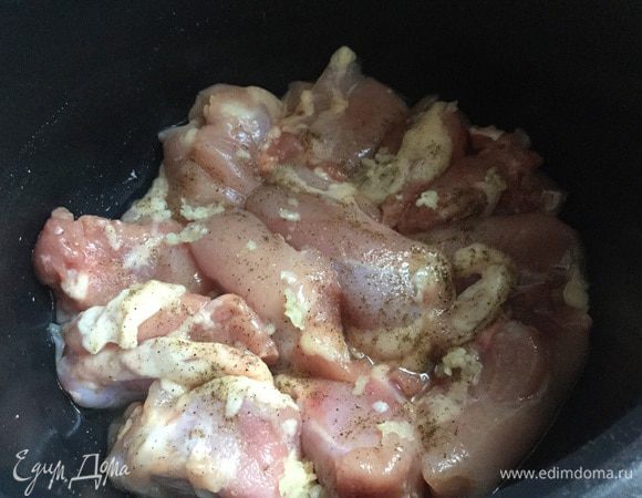 Курицу (у меня было филе без кожи и костей, но можно использовать просто тушку курицу, предварительно разделав на кусочки) выложить в чашу мультиварки, посолить, поперчить. Чеснок выдавить прессом и приправить курицу.