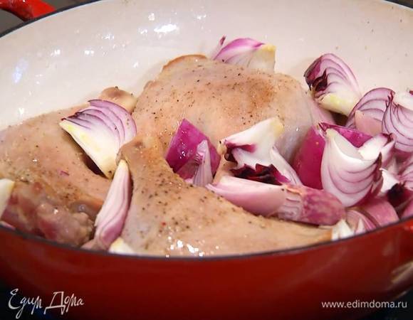 Разогреть в тяжелой, глубокой сковороде оливковое и сливочное масло и обжарить ножки с одной стороны до золотистой корочки, затем перевернуть их и добавить в сковороду лук.