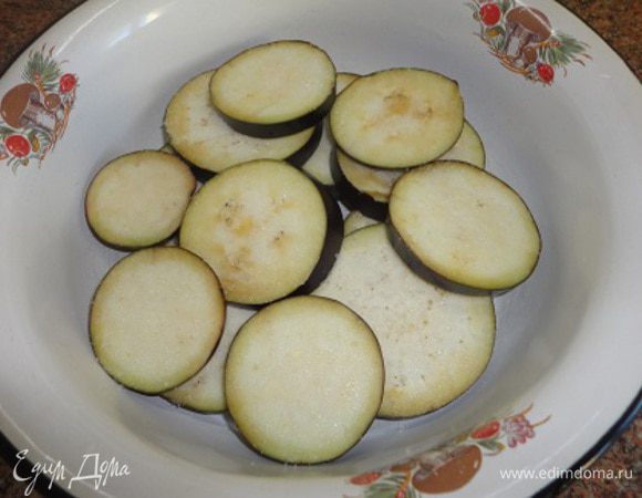 Баклажан (покрупнее) нарезаем кружочками, посыпаем солью и оставляем на минут 15. Включаем духовку для разогрева до 180°C.