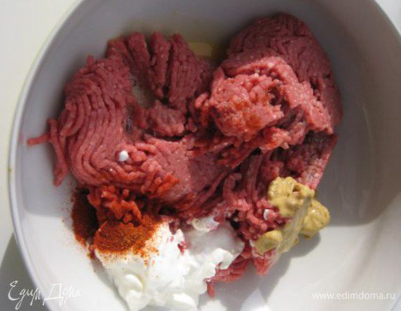 В фарш добавить яйцо, горчицу, сливки (можно заменить на сметану или натуральный йогурт), соль, перец, паприку, хорошо перемешать.