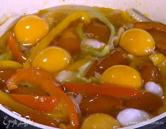 Добавить в сковороду помидоры, посолить, разбить сверху яйца и готовить под крышкой.