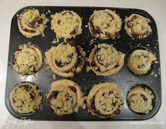 Каждый кусочек поместить в предварительно смазанную тонким слоем растительного масла формочку для маффина. Сверху посыпать песочной крошкой*. Накрыть форму пищевой пленкой и оставить в теплом месте на 30 минут. Затем отправить булочки в духовку 180°C на 20 минут. Время выпечки зависит от вашей духовки.
*Для песочной крошки соединить в миске с помощью вилки муку, сахар и сливочное масло.