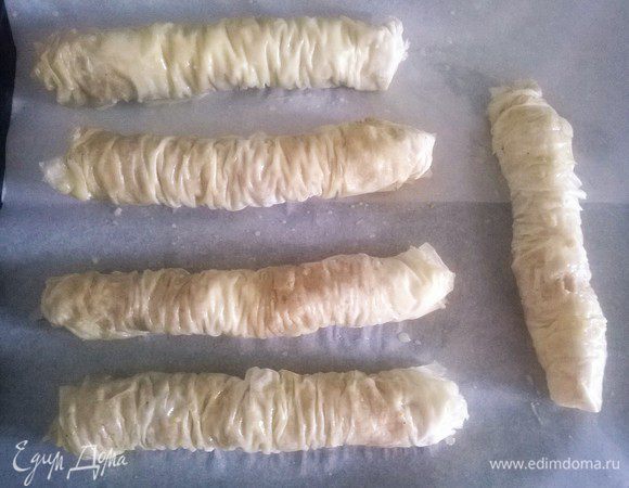 Положить рулон в форму для выпечки и так проделать со всеми листьями фило. 
Смазать топленым маслом.