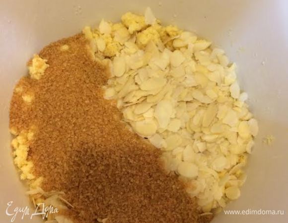 Дабавить сахар, миндальные лепестки и аккуратно перемешать.