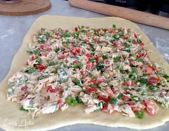 Раскатать тесто в пласт толщиной 0,5 см, разложить начинку, не доходя до одного края 5-8 см.