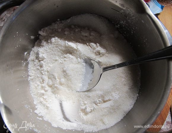 В муку всыпать пудру, добавить желток и нарубленное мелкими кусочками масло. Перетираем смесь руками, превращая в мучную крошку.