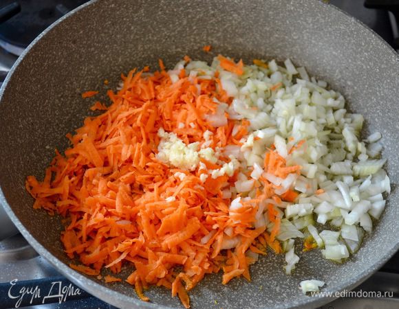 Овощи вымыть. Лук очистить и мелко нарезать, морковь натереть на крупной терке. В большой сковороде разогреть оливковое масло, добавить нарезанные овощи и измельченный зубчик чеснока. Пассеровать все пару минут до размягчения овощей.