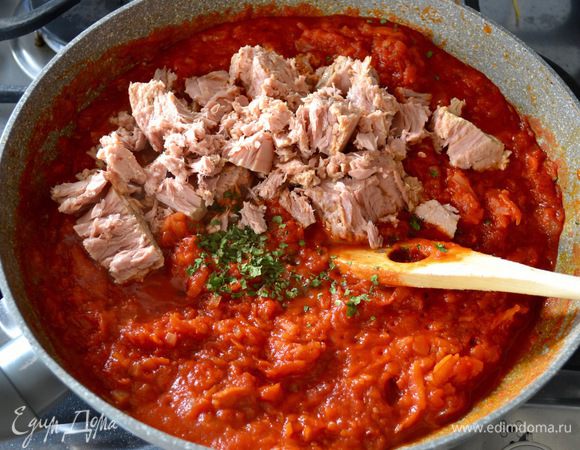 Через указанное время добавить в томатный соус кусочки тунца из банки, предварительно слив жидкость из банки, и нарезанную зелень петрушки. Проверить соус на соль... Потушить все вместе еще минут 5 и снять с огня.