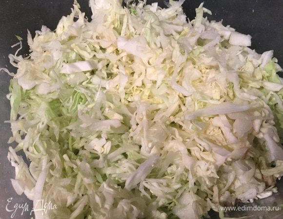 Сначала приготовим начинку: поставьте варить яйца, а пока тонко нашинкуйте капусту.