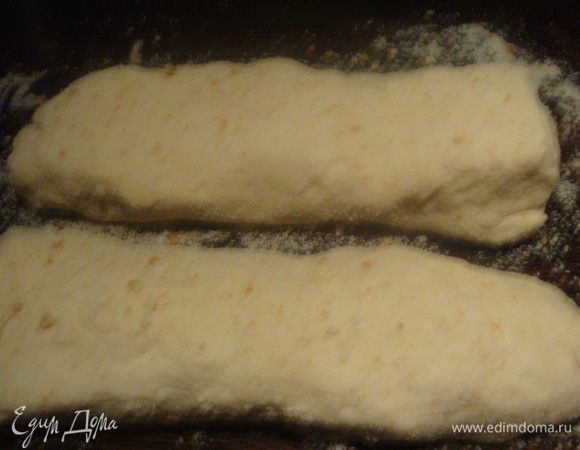 На рабочую поверхность стола насыпать (хлебные крошки) панировочные сухари с белого хлеба. тесто разделить на две части. Скатать два рулета и обвалять в сухарях.