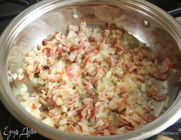 Добавить лук (130 г), нарезанный мелким кубиком. Обжарить с беконом до золотистого цвета.