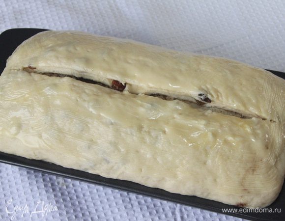 Разогреть духовку до 180°С. 
На буханке сделать насечку глубиной 1 см. Верх хлеба смазать сливочным маслом.
