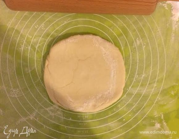 Духовку нагреть до 180°C. Коврик для выпечки посыпать 1 ст. л. муки и начать раскатывать тесто (если нет коврика, то можно тесто раскатать на полотняной салфетке).