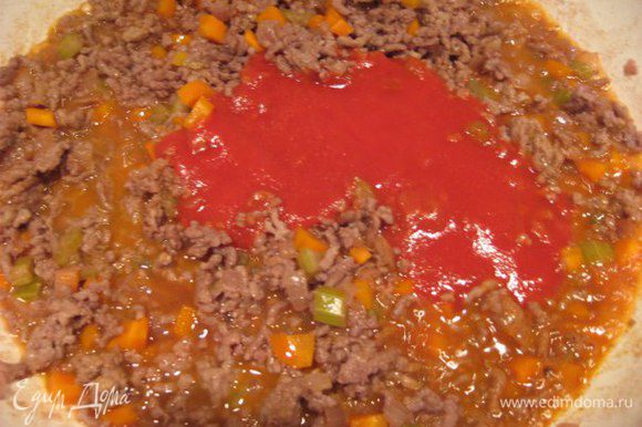 Влить томатный соус (пассату), посолить, добавить специи, если соус кислый, то добавить щепотку сахара. Перемешать, накрыть сковороду крышкой и потушить 20 минут на медленном огне.