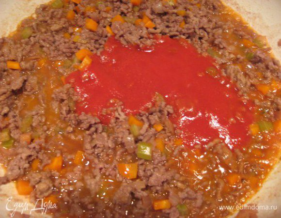 Влить томатный соус (пассату), посолить, добавить специи, если соус кислый, то добавить щепотку сахара. Перемешать, накрыть сковороду крышкой и потушить 20 минут на медленном огне.