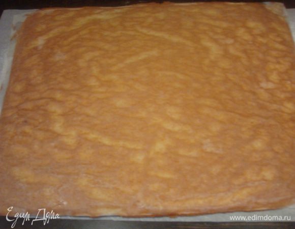 Готовый бисквит переворачиваем на чистый лист пергамента присыпаный сахарной пудрой. Аккуратно снимаем пергамент с бисквита на котором выпекался.