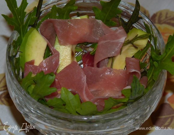 Выложить в салатники листки руколы, авокадо и хамон. Сбрызнуть заправкой.
