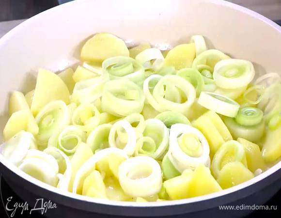 Разогреть в сковороде 2 ст. ложки оливкового масла и обжаривать картофель до появления золотистой корочки, а лук-порей до прозрачности.