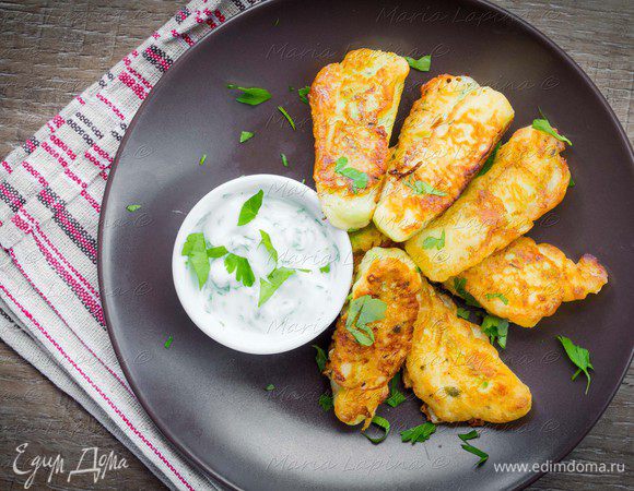 Обваленные в муке кусочки кабачка макаем в кляр и обжариваем на разогретом масле с обеих сторон до румяной корочки. Лучше это делать на среднем огне, так чтобы образовалась корочка и кабачок успел приготовиться. Подаем с соусом из йогурта, чеснока и свежей зелени.