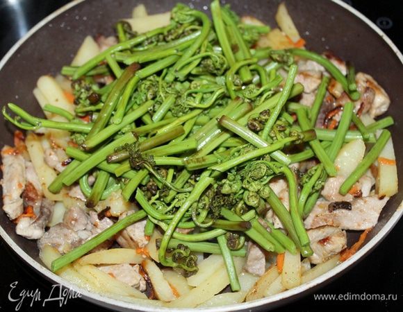 Папоротник отварите в большом количестве соленой воды 5-7 минут, откиньте в дуршлаг, добавьте к картофелю.
Перемешайте, накройте крышкой и тушите 10 мин.