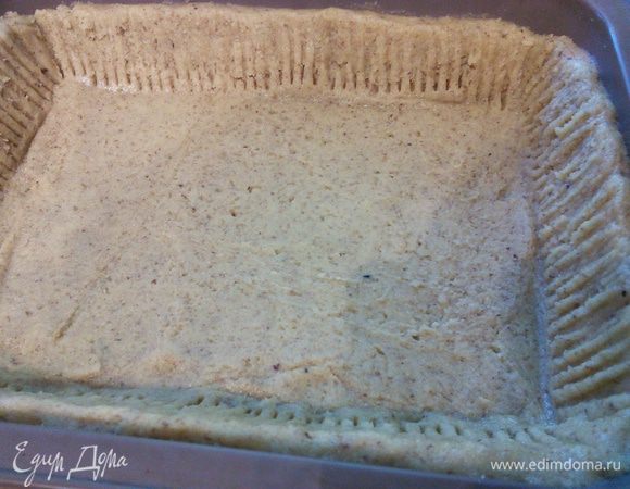 Тесто распределить по форме (20x25 см), образуя бортики. Духовку разогреть до 175°C и запекать тесто в течении 10-12 минут. 