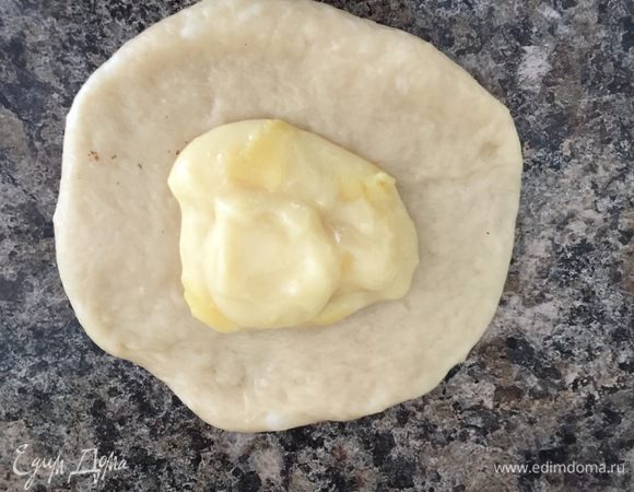 Кусочки по 50 г раскатываем в лепешечку, в центр выкладываем полную чайную ложку крема.